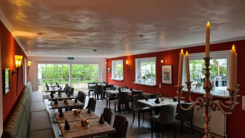 卡珀尔恩诗莱门德酒店的一间带桌椅和红色墙壁的餐厅