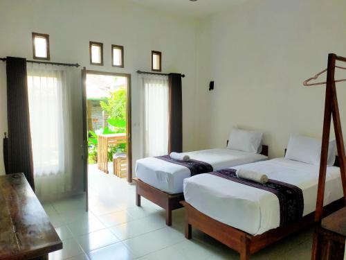 龙目岛库塔Mango Room Mandalika的一间带两张床的卧室和一个阳台
