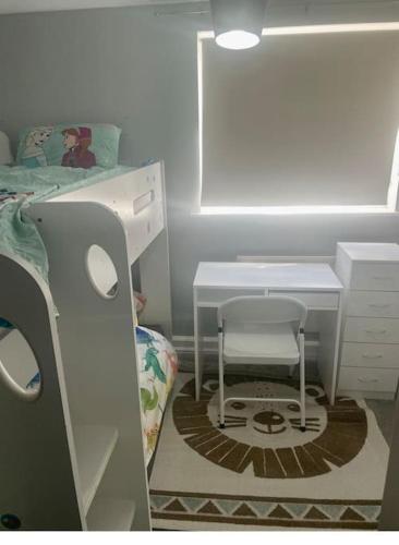 达格纳姆Family Apartment in London Wi-Fi and free parking的一间卧室配有一张床、一张桌子和一把椅子