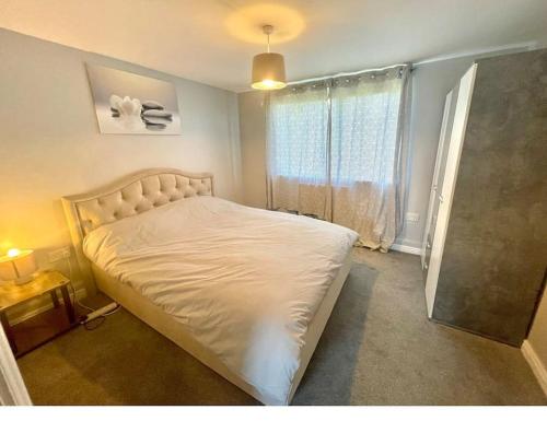 达格纳姆Family Apartment in London Wi-Fi and free parking的卧室配有白色的床和窗户