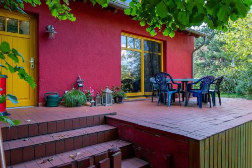 格赫伦-莱宾Ferienhaus Göhren-Lebbin的红色房子前方的带桌椅的庭院