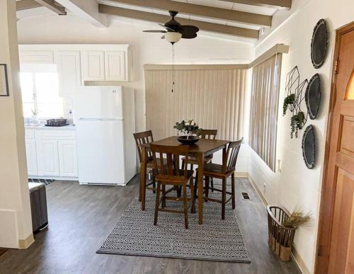 二十九棕榈村Joshua Tree National Park - Cozy Palms Getaway的厨房配有桌椅和白色冰箱。