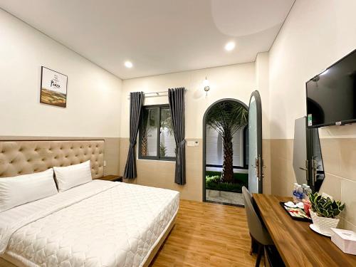 永隆VÂN TRANG GARDEN HOTEL 2的一间卧室配有一张床、一张书桌和一个窗户。