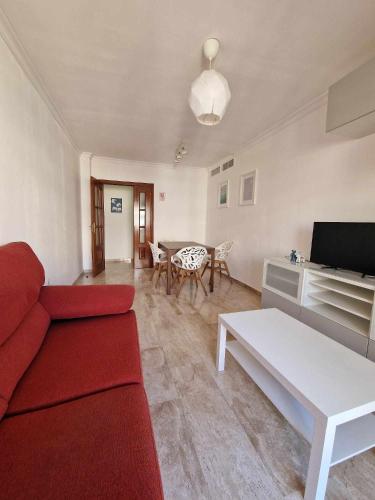 马拉加2 rooms con piscina litoral的客厅配有红色的沙发和桌子