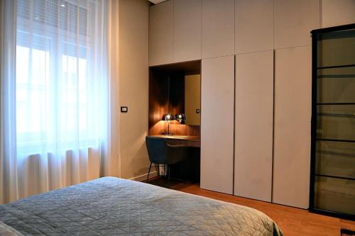 萨格勒布Nino Luxury Apartment的一间卧室配有一张床、一张书桌和一个窗户。