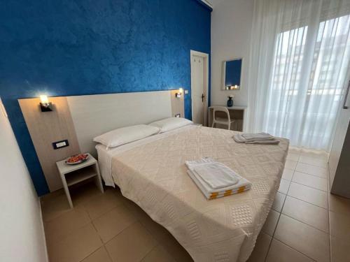 里米尼Hotel Le Ali的卧室配有白色床和蓝色墙壁
