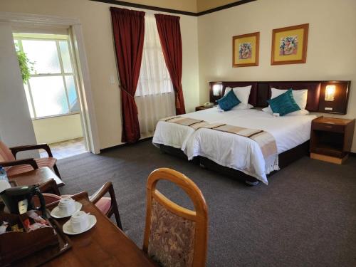 莱迪史密斯Royal Hotel Ladysmith的酒店客房配有一张床铺和一张桌子。