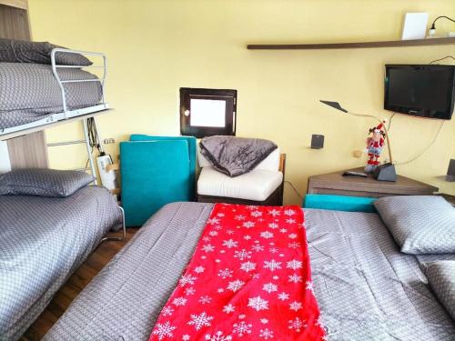 布勒伊-切尔维尼亚Cozy little studio in cervinia的客房设有两张双层床和红色毯子。