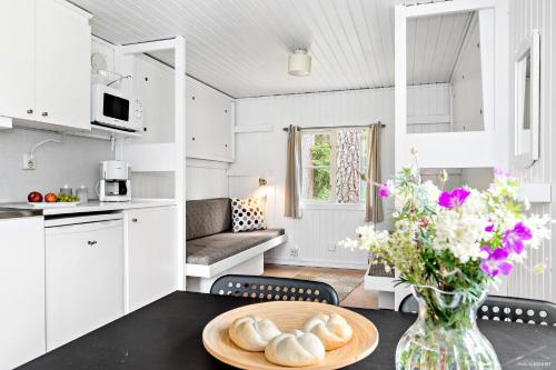 科尔莫登First Camp Kolmården-Norrköping的厨房以及带花瓶桌子的客厅。