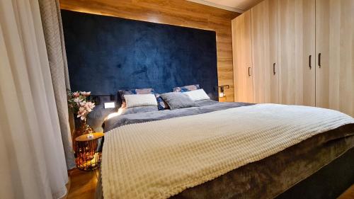 班斯科Apartmanica Double room apartment with balcony, St Ivan Rilski 4 star SPA Resort, Bansko的一间卧室设有一张蓝色墙壁的大床