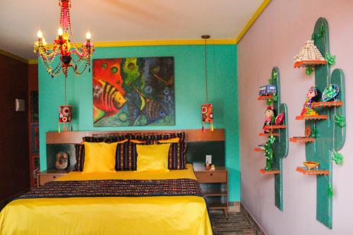 安谢塔Pousada No Meio do Mundo的卧室配有黄色的床和墙上的绘画作品
