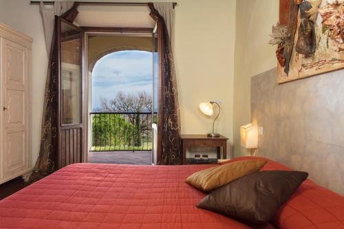 圣吉米尼亚诺堡CASA GIOVANNA的一间卧室配有一张红色的床,设有一扇开放式门
