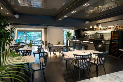 卡拉马塔Garden City Resort的一间带桌椅的餐厅和一间酒吧