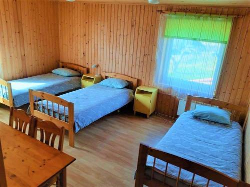 TuhalaTuhala Jarve Talu的客房设有两张床、一张桌子和一张桌子。