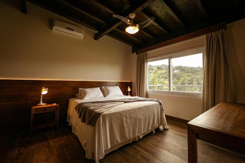 普腊亚罗萨Fazenda Verde - Praia do Rosa的一间卧室设有一张大床和一个窗户。