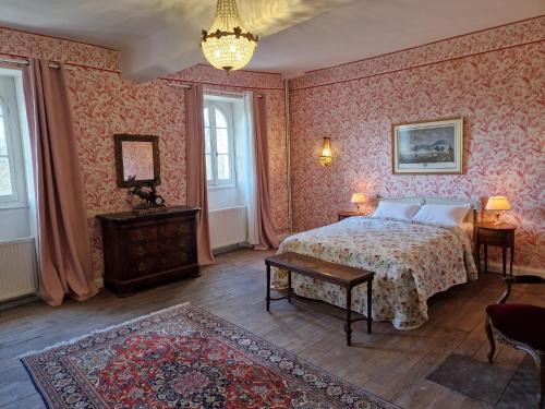 Saint-JustinChâteau St Justin的一间卧室配有一张床和一个吊灯