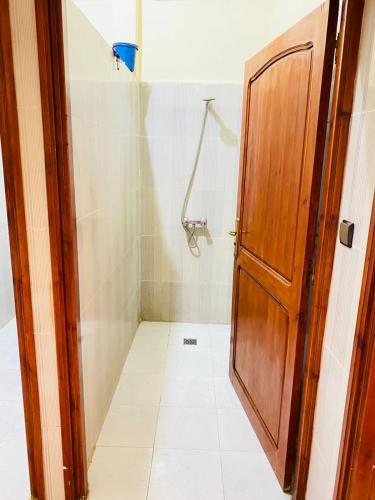 依索安Sea Surf House Imsouane的带淋浴的浴室和木门。