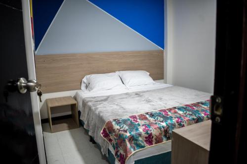 波哥大Hotel Santo Tomas Bogota的一间小卧室,配有一张蓝色墙壁的床