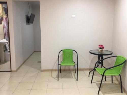 Santiago EsteRivera Family Apartments的一张桌子和两把椅子,一张桌子和花瓶