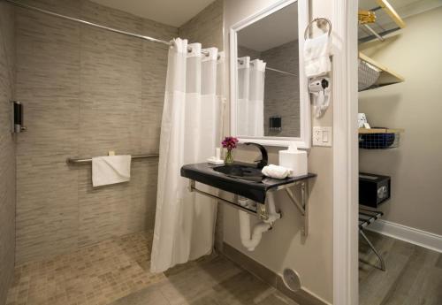 迈阿密Nuvo Suites Hotel - Miami Doral的一间带水槽和淋浴的浴室