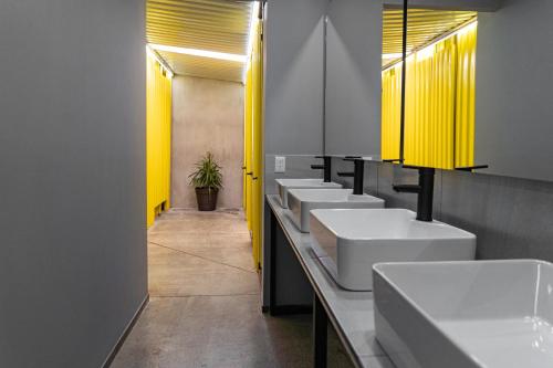 瓜达拉哈拉CHECK INN HOSTAL AEROPUERTO GDL的浴室里一排黄色的盥洗盆