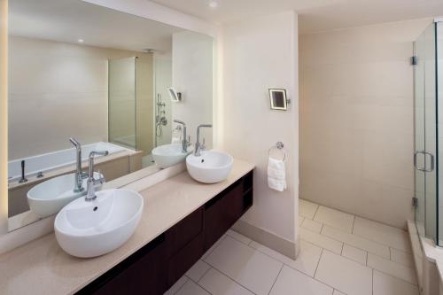 长滩阿乐格利亚酒店的浴室设有2个水槽和2面镜子