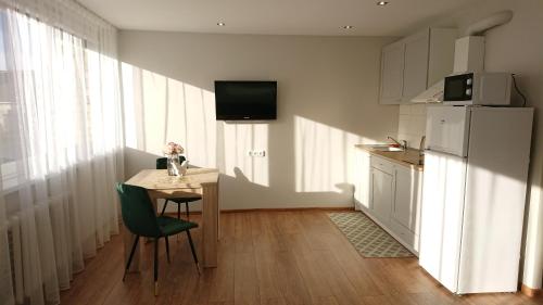 希奥利艾Stay in center #Šiauliai的厨房配有桌椅和冰箱。