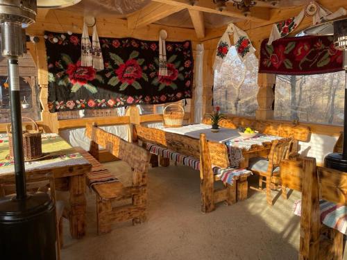 BudeştiCabanele Rus的小屋内带木桌和椅子的用餐室