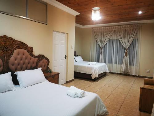 LusikisikiKwaNomzi Botique Lodge的酒店客房设有两张床和窗户。