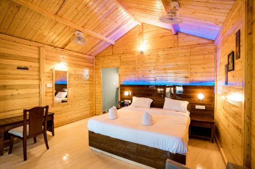 阿贡达orange sky beach bungalow的木制客房内的一间卧室,配有一张床