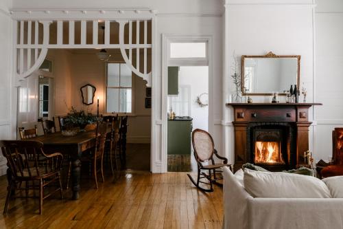 马莱尼墨兰莉小屋酒店的客厅配有桌子和壁炉