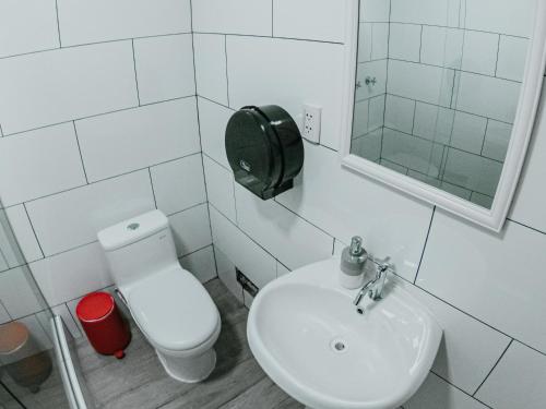 利马Alpes Lima Kennedy Hostel的白色的浴室设有卫生间和水槽。
