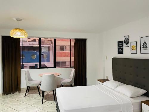 利马Alpes Lima Kennedy Hostel的卧室配有一张床和一张桌子及椅子