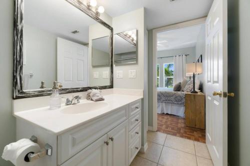 马可岛Collier Condo #202的一间带水槽和镜子的浴室以及一间卧室