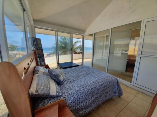 马萨特兰Casa a pie de playa isla de la piedra的一间卧室配有一张床,享有海滩美景