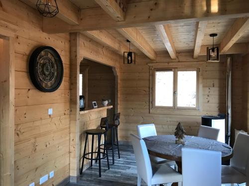 AlièzeForest Jura Lodge - Chalet des sapins的小木屋内的用餐室,配有桌椅