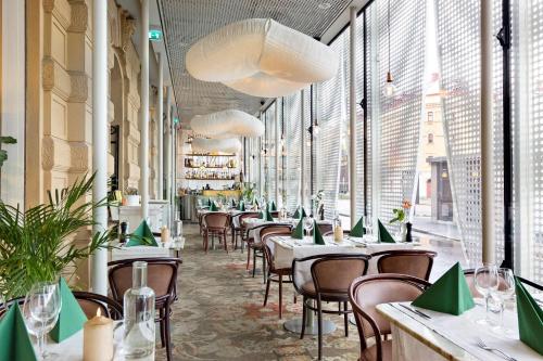 松兹瓦尔波罗的海贝斯特韦斯特酒店的餐厅设有桌椅和大窗户。