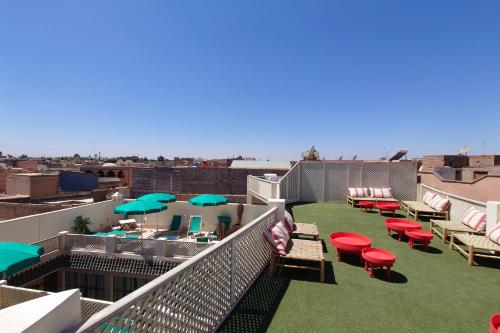 马拉喀什Miostello Lifestyle Hostel Marrakech的屋顶上带椅子和遮阳伞的阳台