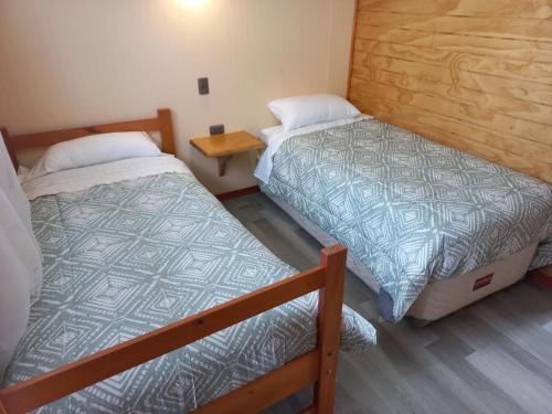 Quilquico柯尼可农家乐的客房设有两张床,铺有木地板。