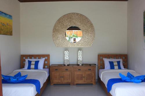 沙努尔英达2号别墅的一间卧室配有两张床和镜子