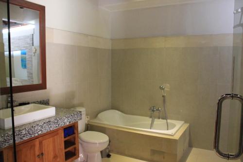 沙努尔英达2号别墅的带浴缸、卫生间和盥洗盆的浴室