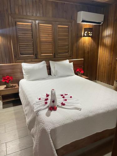 圣斐利-银港Hacienda La Huerta Puerto Plata, 1 BDR的卧室配有带玫瑰花的白色床
