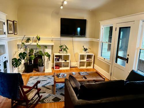 波特兰Forest Park Sanctuary的客厅配有沙发和墙上的电视