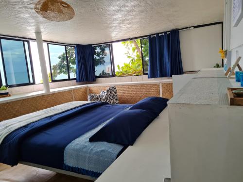 麦岛The Hut Koh Mak Sea View的一间卧室配有一张带蓝色床单的大床