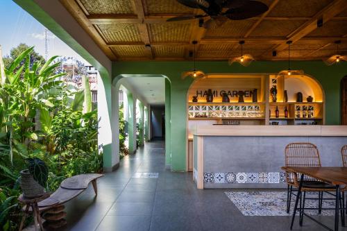 Buôn JuHami Garden - Authentic & Natural Resort的一间拥有绿色墙壁的餐厅和一间酒吧