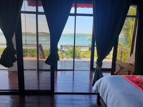 New BusuangaMiley Lodging Restobar的一间卧室配有一张床,享有海景