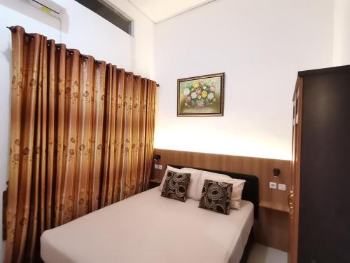 巴图美丽别墅度假屋的配有窗帘的客房内的小床