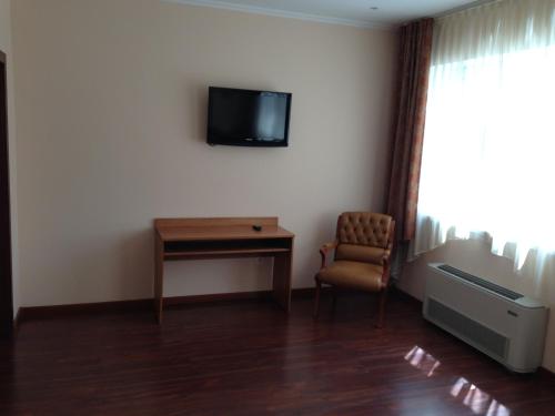 克拉斯诺亚尔斯克德芙里克酒店的客房设有书桌、电视和椅子。