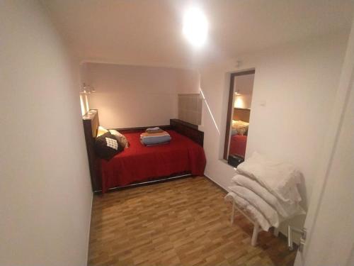 阿尔玛根Ginjals 67的一间设有红色床和镜子的小卧室
