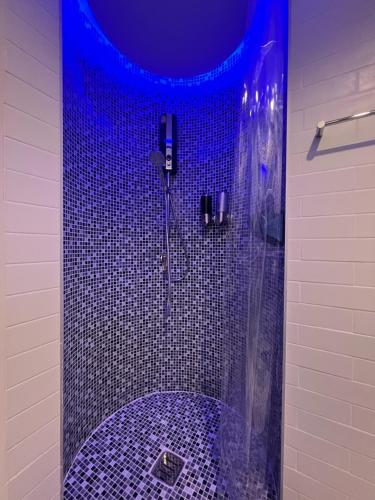 华欣Stardust Boutique Hotel的浴室配有蓝色淋浴和浴缸